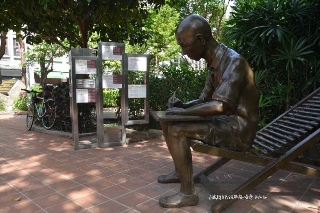 雕塑坐在涼躺椅伏案寫詞李臨秋雕像